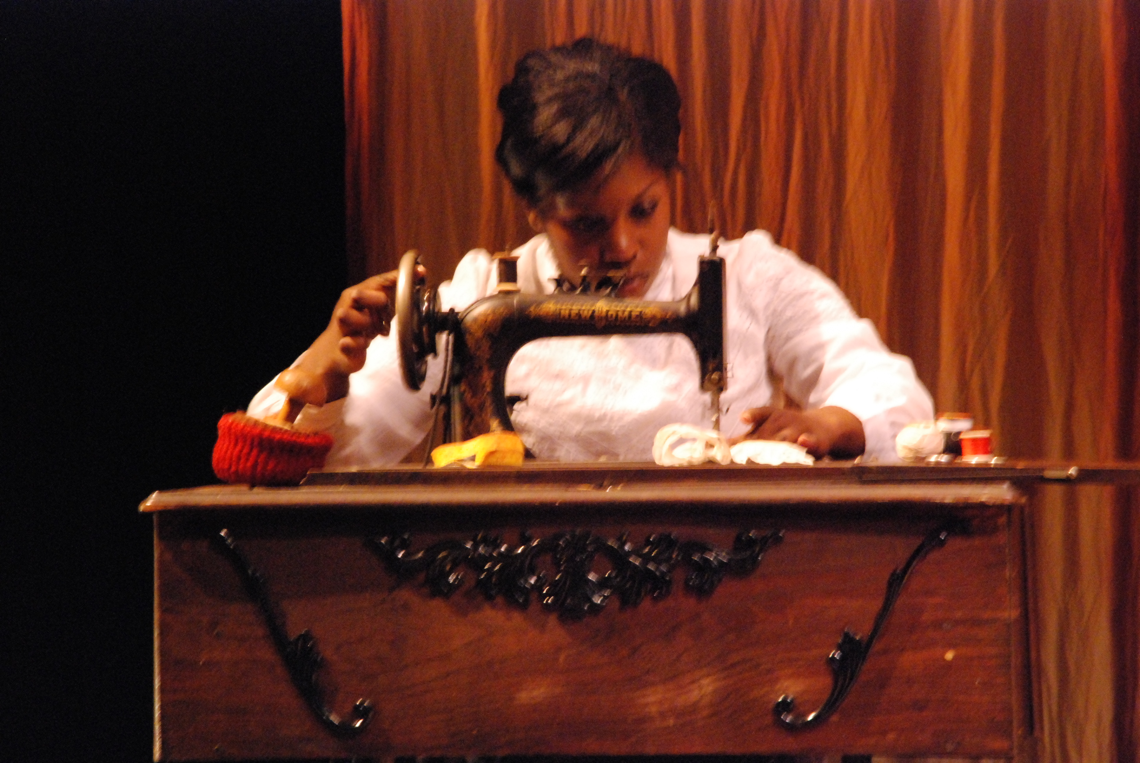 Character Esther at the sewing machine
